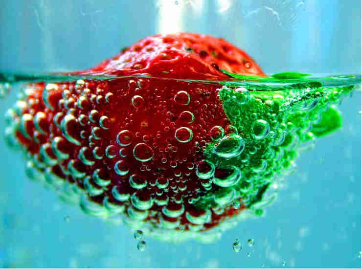 Fotografía de una fresa sumergida en sprite.