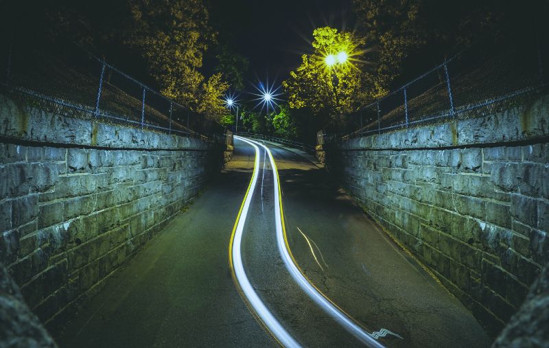 Fotografía de un camino de luz creado por la luz de un vehículo muy rápido