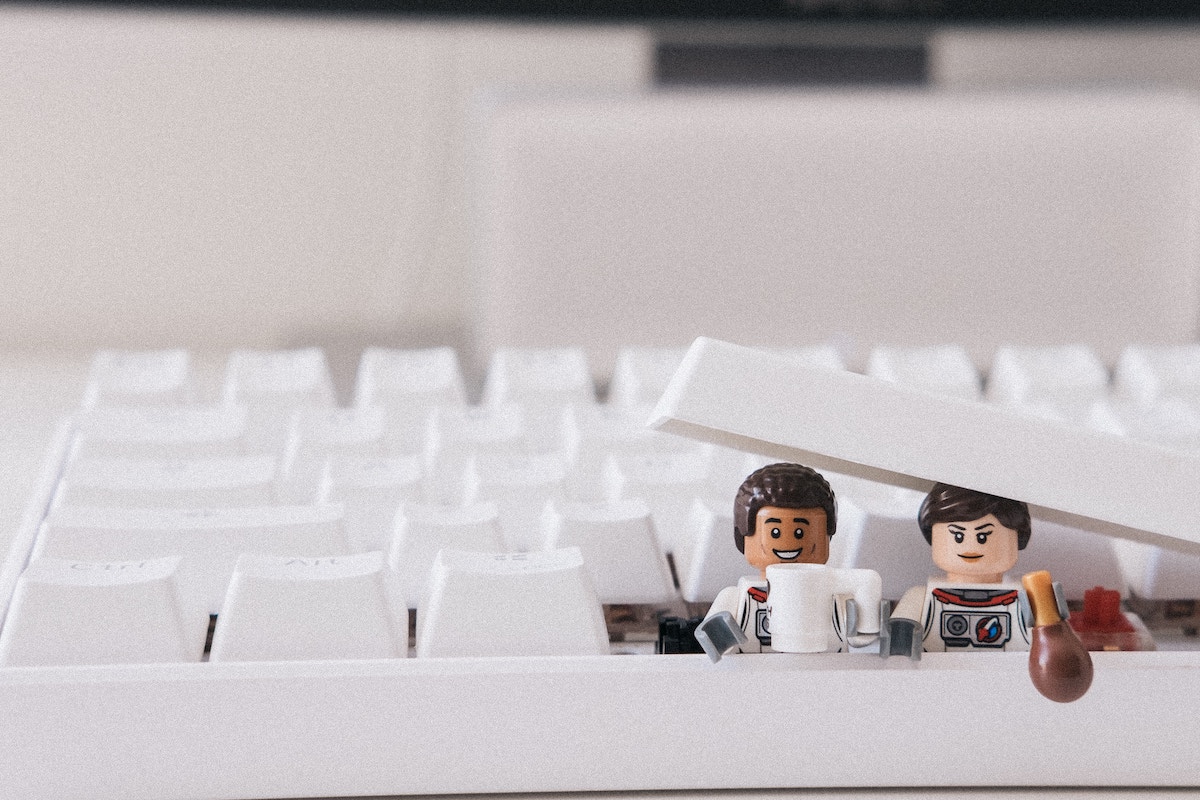 Figuras de lego saliendo de un teclado blanco